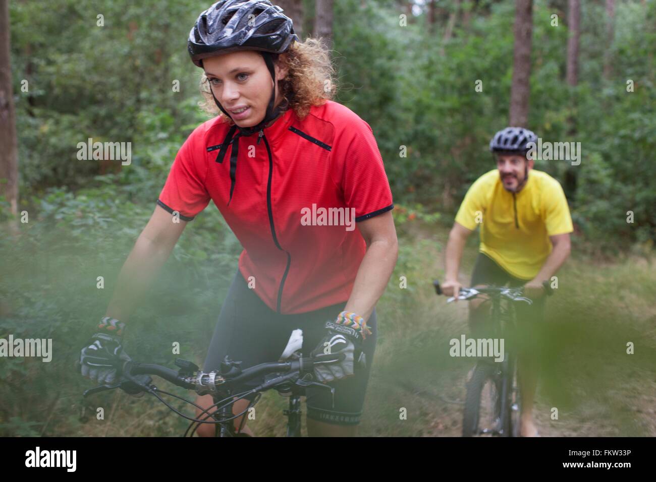 Mountain Biking couple walking through forest Banque D'Images