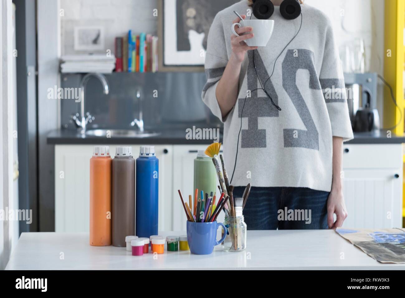 Artiste féminine de boire du café à la table de cuisine Banque D'Images