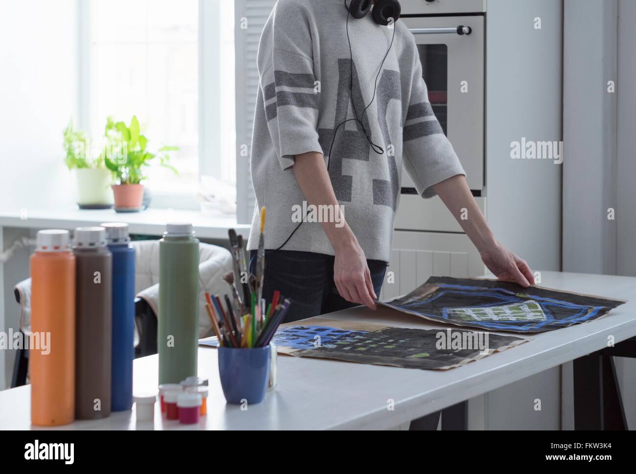 L'artiste féminine de la préparation à la peinture à table de cuisine Banque D'Images