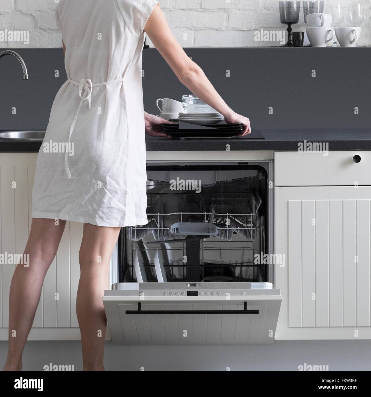 Vue arrière de chargement en plats femme lave-vaisselle Banque D'Images
