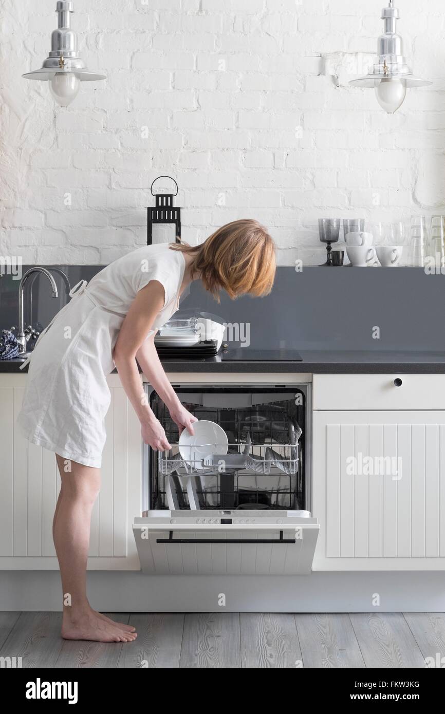 Femme en plats chargement lave-vaisselle Banque D'Images