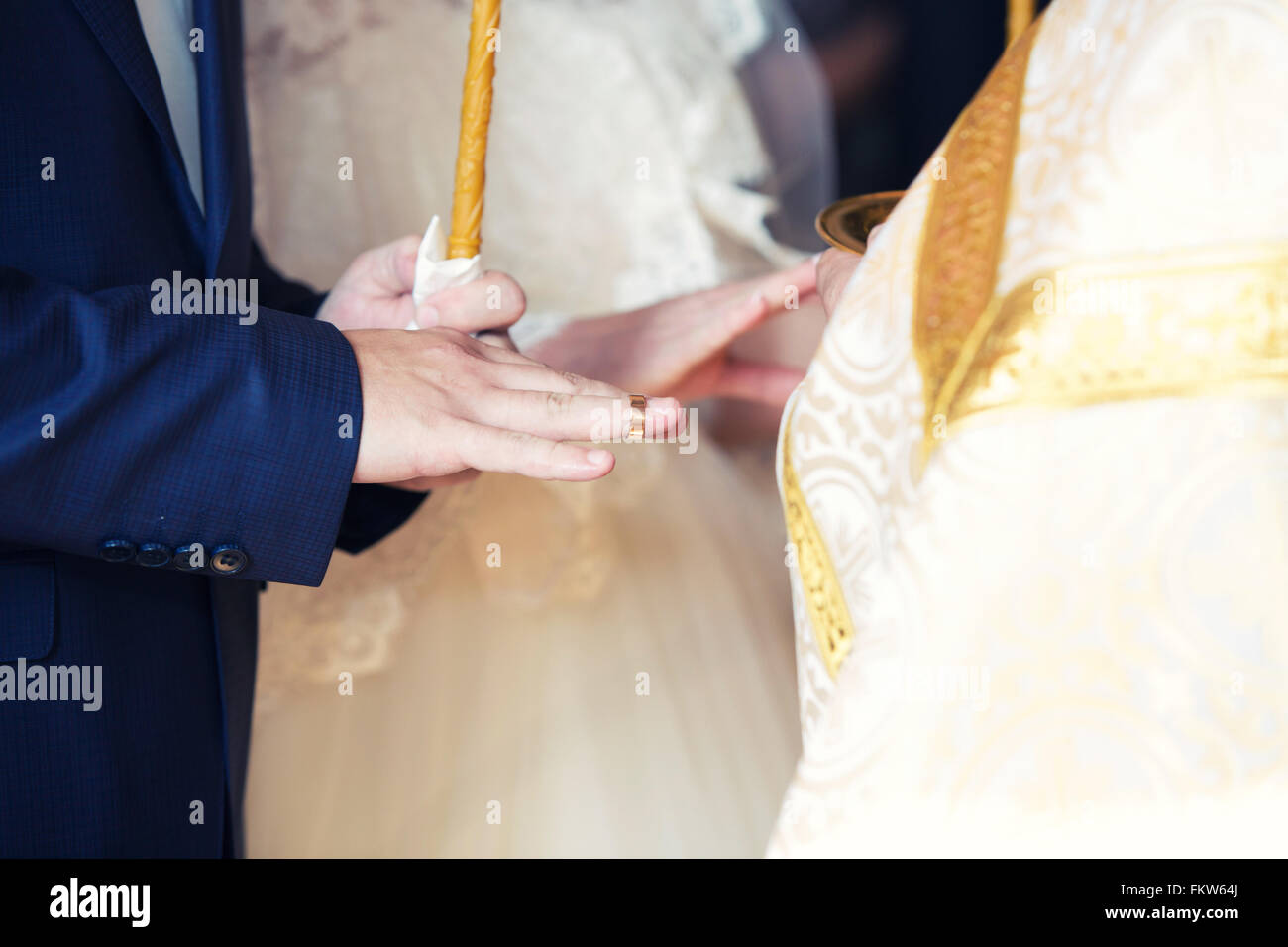 Le prêtre robes une bague sur un doigt pour le marié au cours de mariage à l'église Banque D'Images Le prêtre robes une bague sur un doigt pour le marié au cours de mariage à l'église Banque D'Images