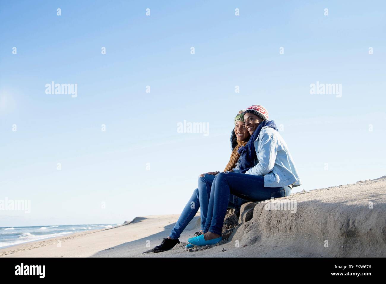 Deux amis assis sur plage, looking at view Banque D'Images