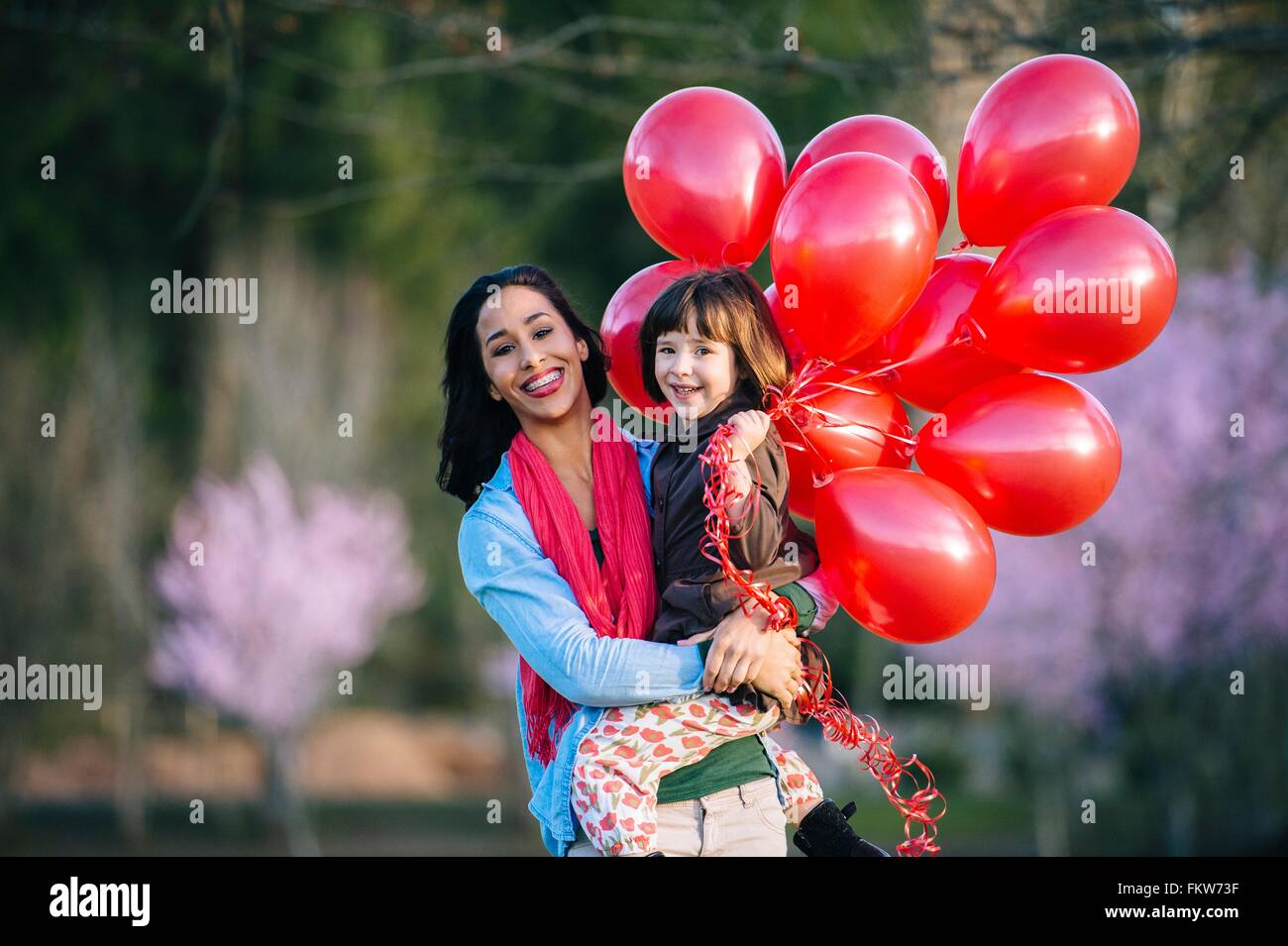 Portrait de jeune femme et sa fille avec bouquet de ballons rouges dans la région de park Banque D'Images