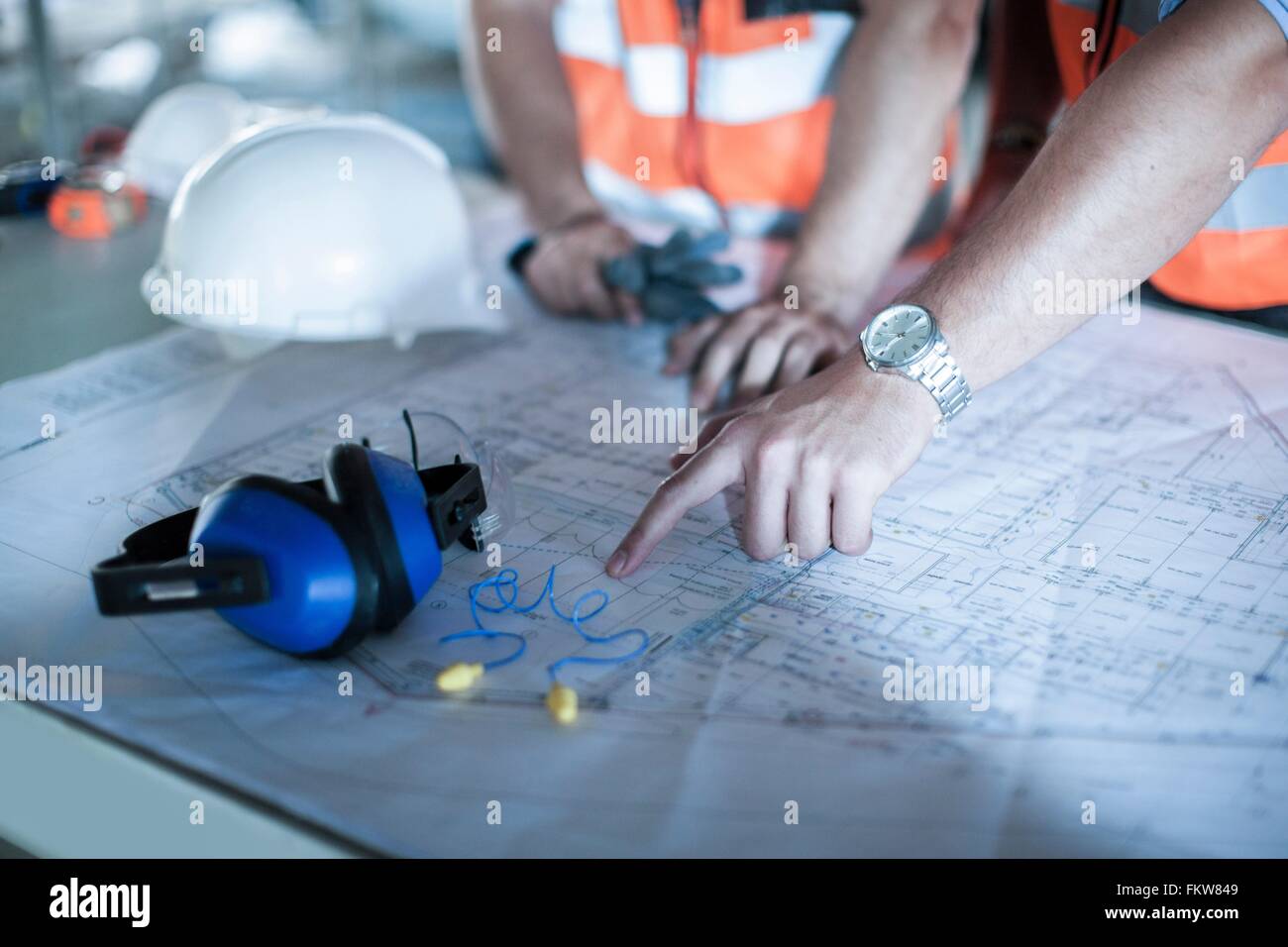 Close up of male main pointant sur le plan du site en construction Banque D'Images