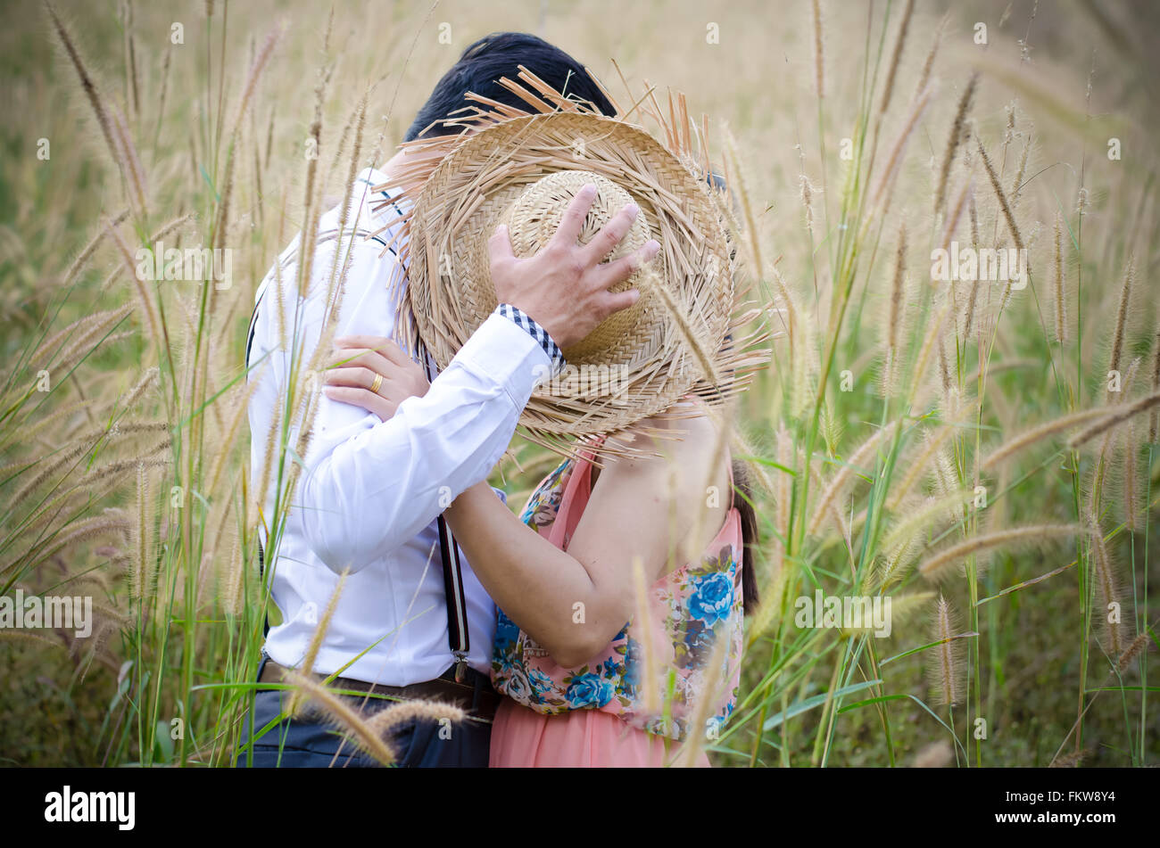 Couple baiser et embrasser dans grass field Banque D'Images