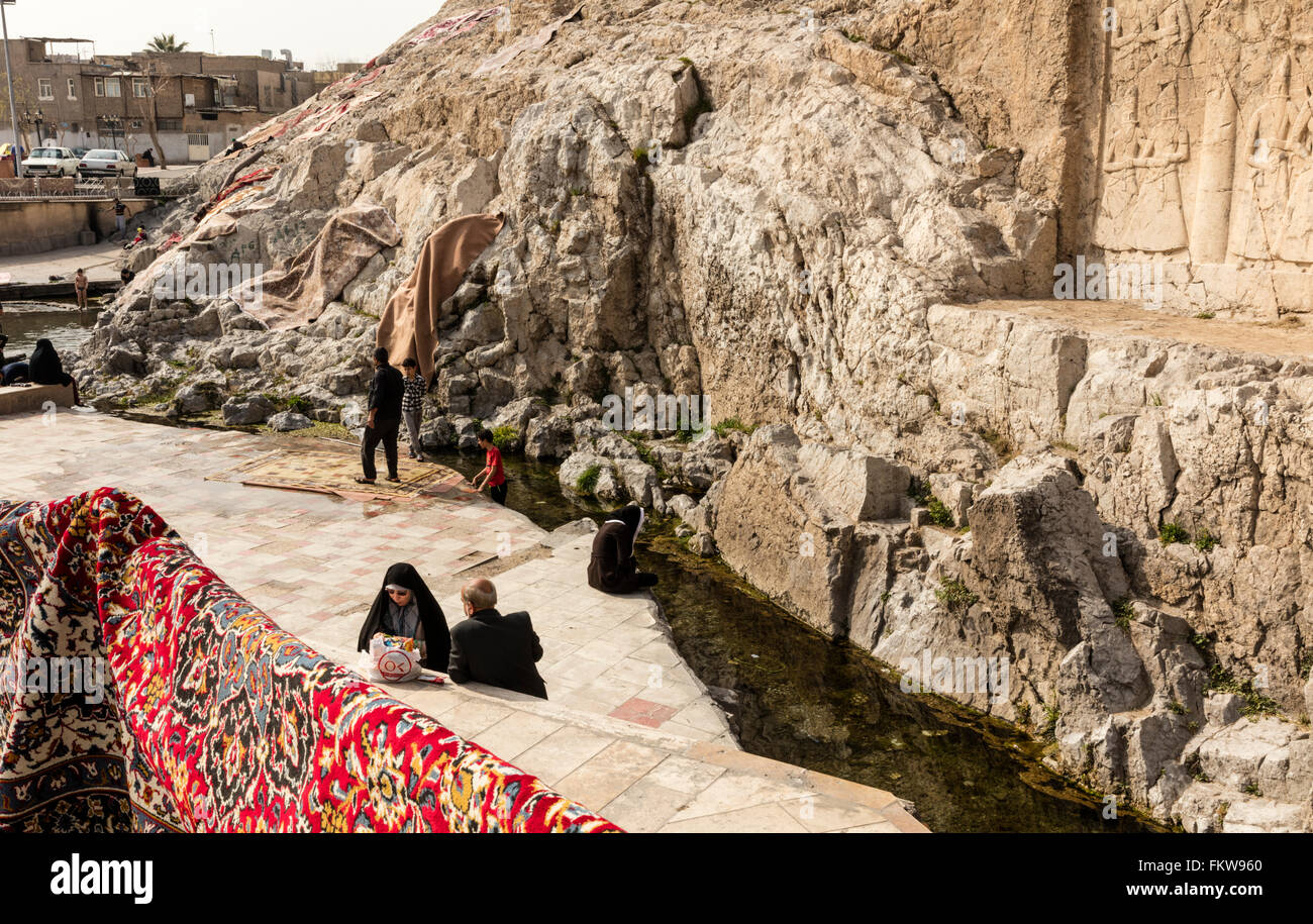 Lavage de tapis traditionnel à l'Cheshmeh Ali printemps à Rayy dans le sud de Téhéran. Époque qajare haut relief visible à droite. Banque D'Images