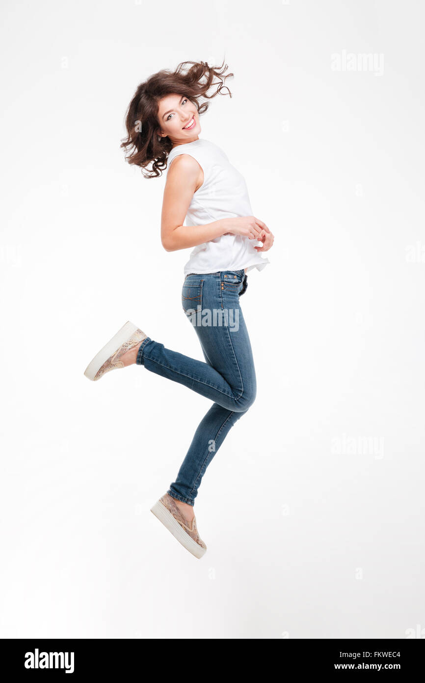 Portrait of a smiling woman jumping isolé sur fond blanc Banque D'Images