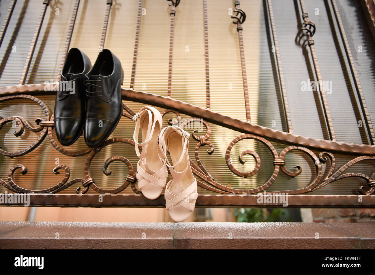 Groom chaussures noires et blanches chaussures suspendu dans une clôture en fer forgé Banque D'Images