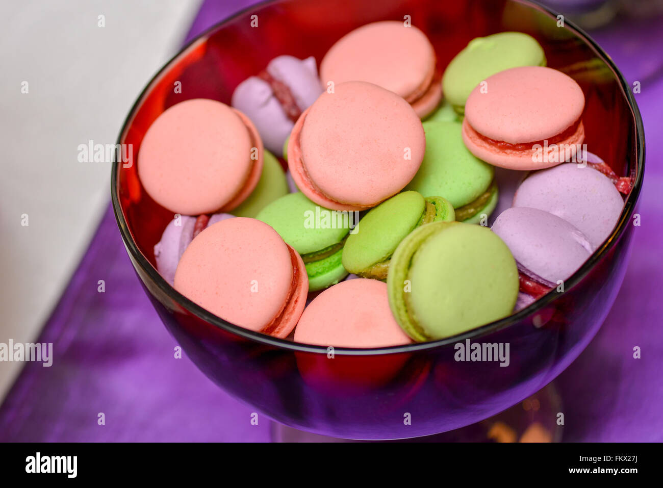 Rose, vert et violet macarons sur une plaque de verre Banque D'Images