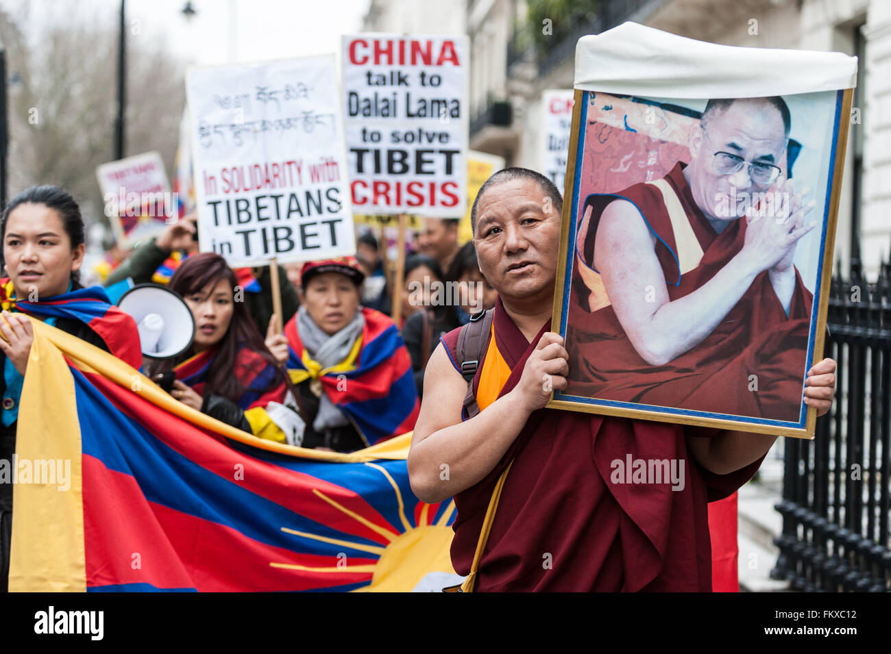 Londres, Royaume-Uni. 10 mars 2016. Recueillir l'extérieur de l'londoniens tibétain Ambassade de Chine à Portland Place appelant à "la justice au Tibet', avant de marcher à travers le centre de Londres, dirigé par un moine bouddhiste de réfugiés (en photo, portant une photo du dalaï-lama). Ils se sont réunis pour commémorer le 57e anniversaire du soulèvement national tibétain (lorsque des milliers de Tibétains ont été tués au cours d'une révolte de Lhassa pour protéger le dalaï-lama des troupes chinoises et de l'occupation de leur pays). Crédit : Stephen Chung / Alamy Live News Banque D'Images