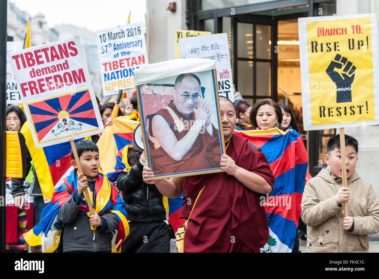 Londres, Royaume-Uni. 10 mars 2016. Recueillir l'extérieur de l'londoniens tibétain Ambassade de Chine à Portland Place appelant à "la justice au Tibet', avant de marcher à travers le centre de Londres, dirigé par un moine bouddhiste de réfugiés (en photo, portant une photo du dalaï-lama). Ils se sont réunis pour commémorer le 57e anniversaire du soulèvement national tibétain (lorsque des milliers de Tibétains ont été tués au cours d'une révolte de Lhassa pour protéger le dalaï-lama des troupes chinoises et de l'occupation de leur pays). Crédit : Stephen Chung / Alamy Live News Banque D'Images