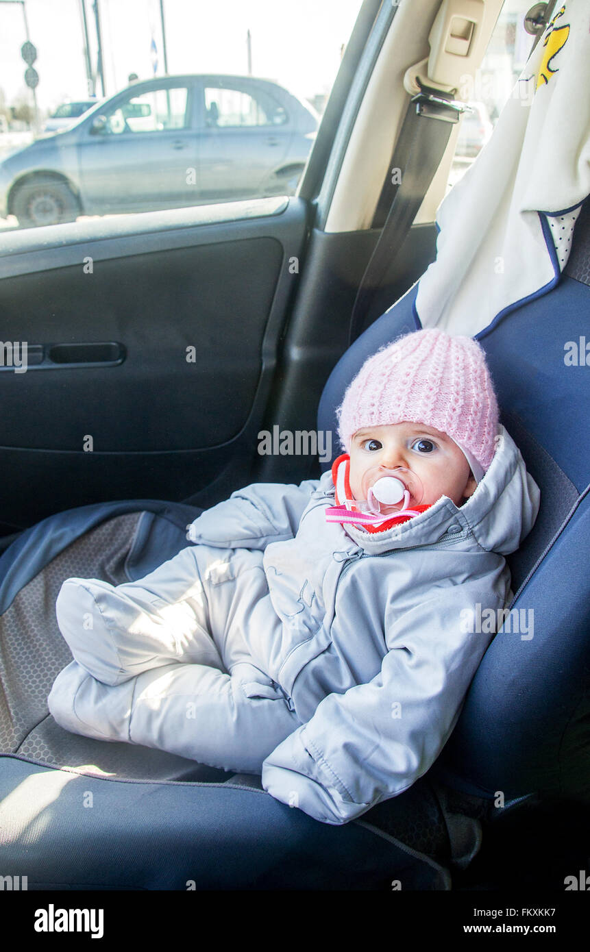 Nouveau-né dans la voiture assis sur siège avant habillé pour l'hiver onesie Banque D'Images