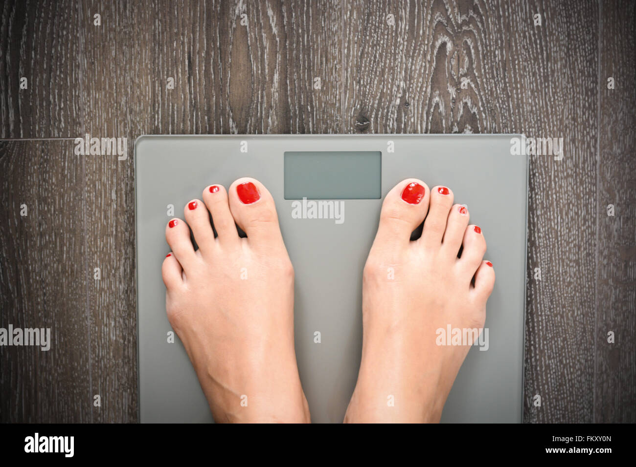 Perdre du poids ou suivre un régime concept avec personne sur une échelle mesurant le kilogrammes Banque D'Images