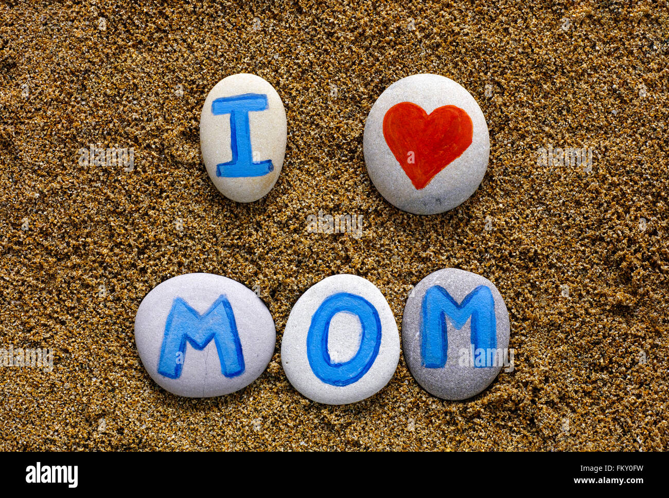 Mots QUE J'aime maman énoncer des pierres avec des lettres et le coeur sur le sable de la mer. Lettres dessiné par moi Banque D'Images