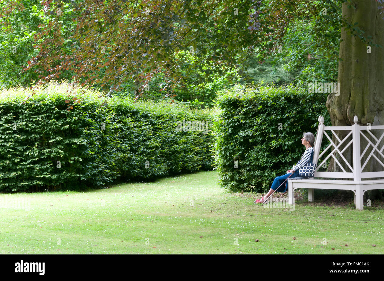 Un visiteur se détend dans l'enceinte de la maison, Kent. Chevening Banque D'Images