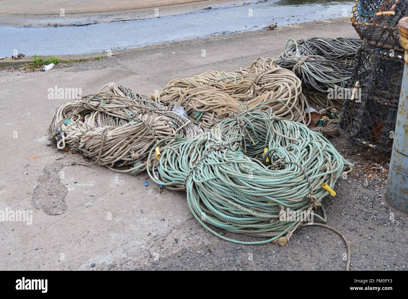 Corde sur le quai en face. Trois bobines. Mur du port de St Andrews en Écosse Banque D'Images
