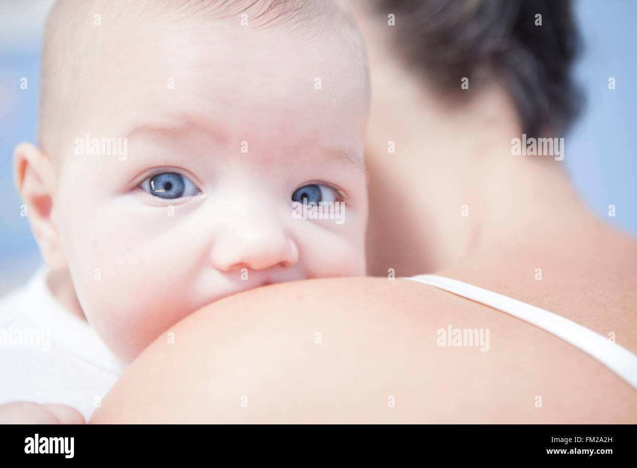 Portrait d'un bébé de quatre mois sur l'épaule de sa maman Banque D'Images