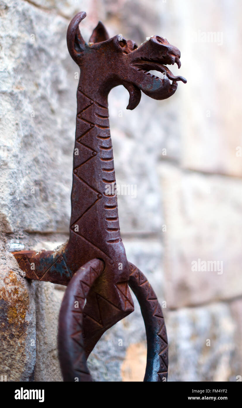 Poignée en forme d'un anneau en métal, avec une figure d'un dragon construit dans le mur du château médiéval de vignerons dans le style italien Banque D'Images