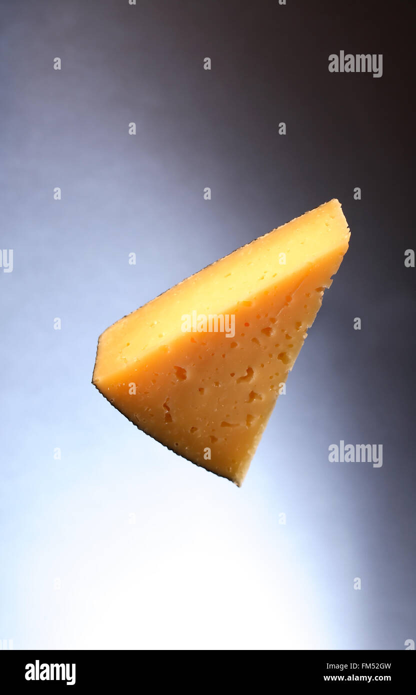 Morceau de fromage gruyère sur beau fond sombre Banque D'Images