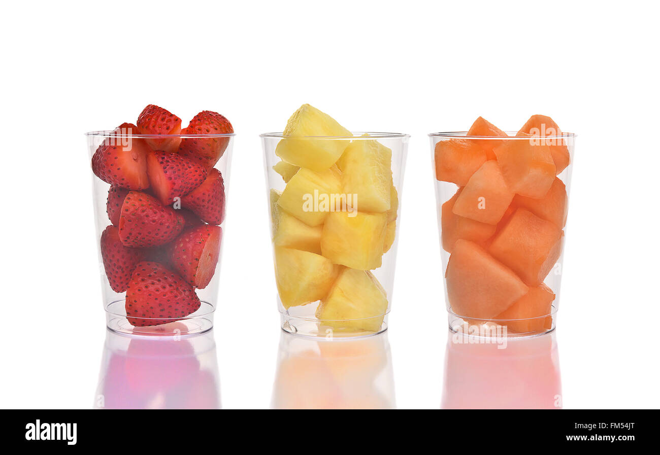 Trois coupes de fruits frais sur blanc avec réflexion. Les fraises, ananas et melon dans des gobelets en plastique. Banque D'Images