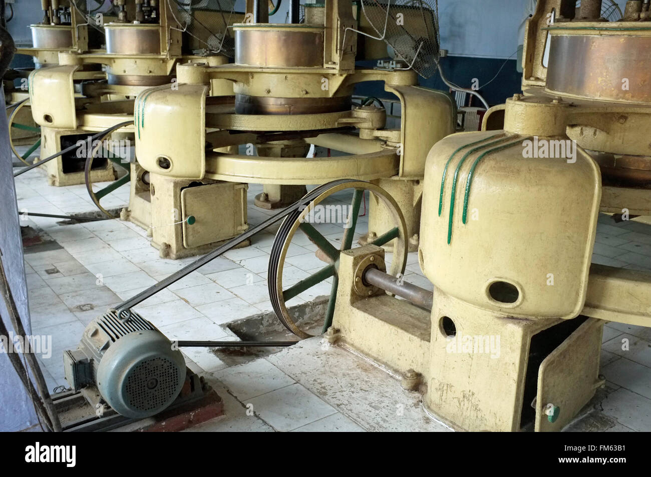 Machines de meulage et d'appuyer sur un plateau à l'Puttabong (Tukvar) l'usine de transformation de plantation de thé, Darjeeling, West Bengal, India. Banque D'Images