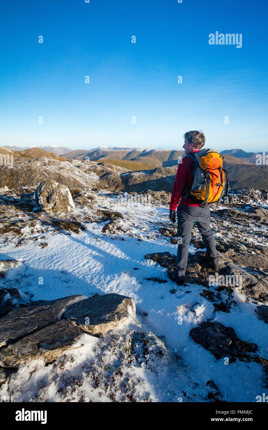 Walker d'hiver au sommet des montagnes Maumturk, Knocknahillion, Connemara, comté de Galway, Irlande. Banque D'Images