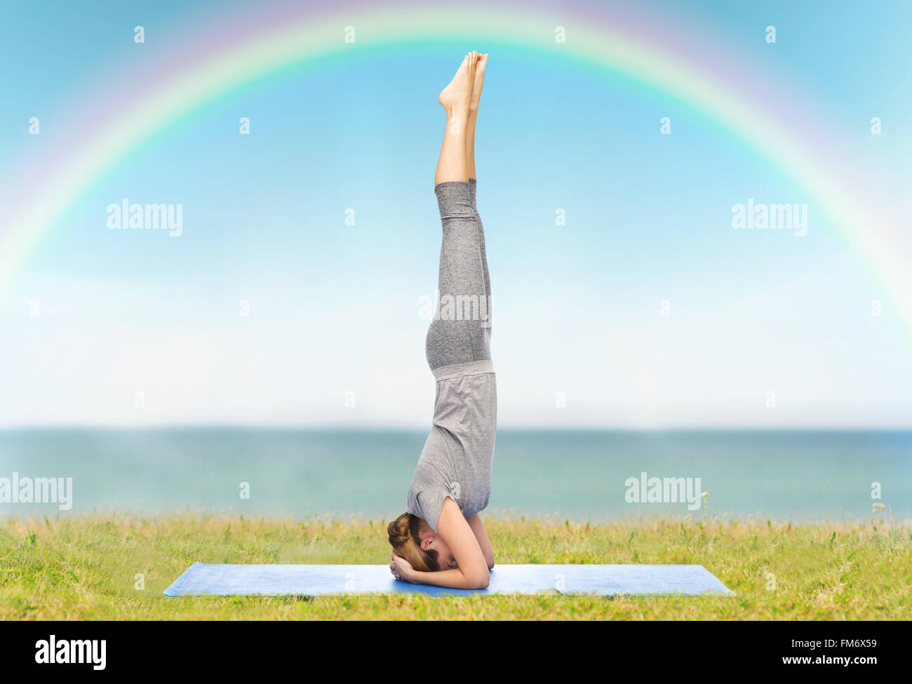 Femme faisant du yoga dans la tête poser sur mat Banque D'Images