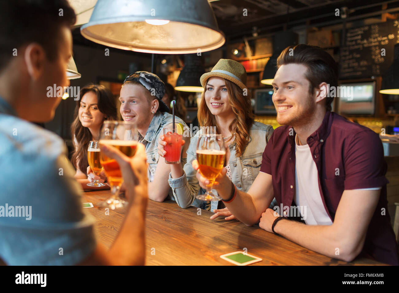 Happy friends avec un verre au bar ou au pub parle Banque D'Images