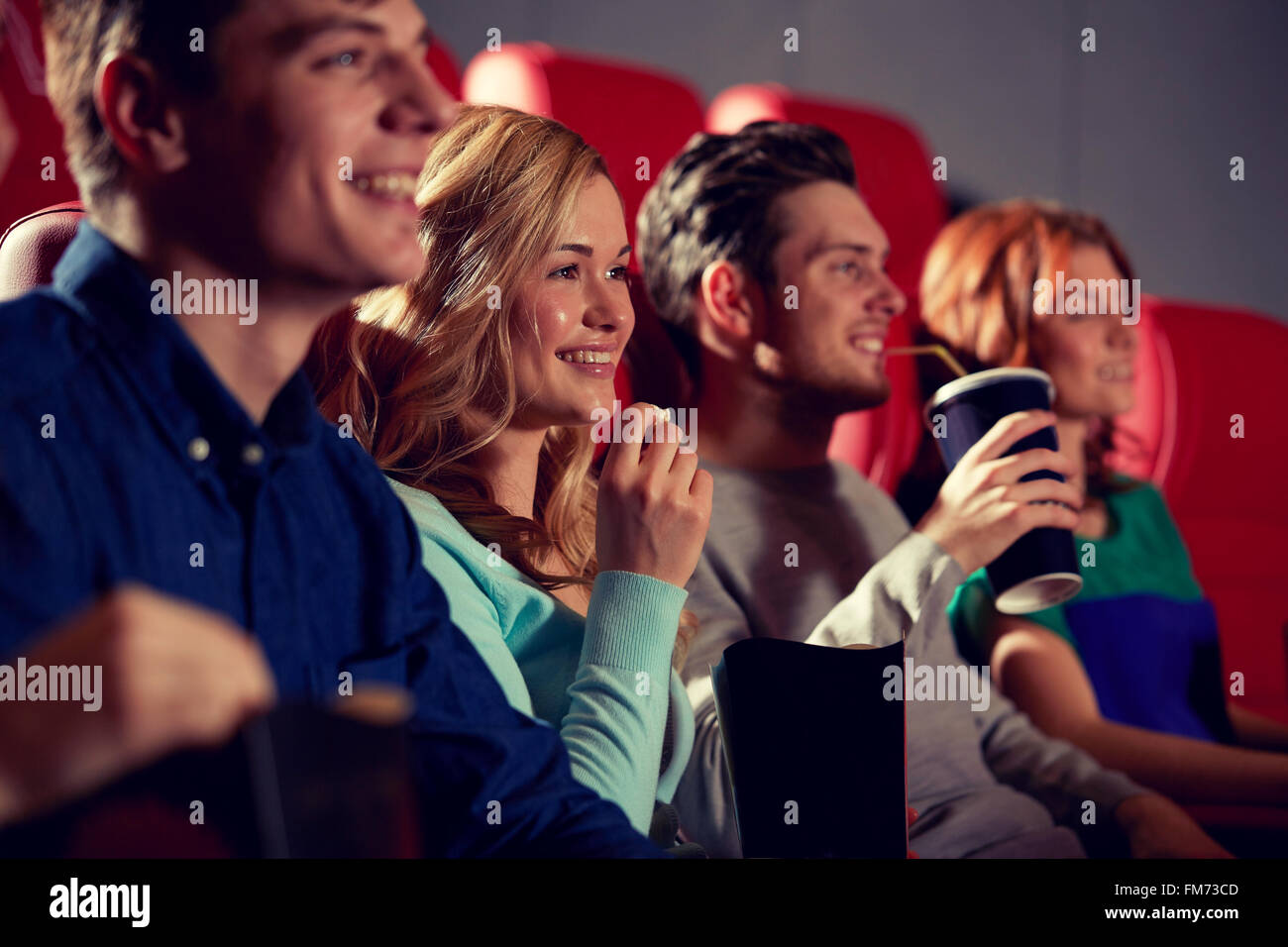 Happy friends watching movie in theatre Banque D'Images