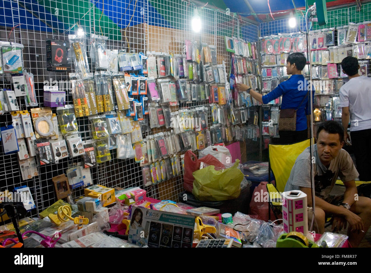 Les jeunes hommes sont à la recherche de téléphone portable à une foire de rue dans la région de Kampong Cham, au Cambodge. Banque D'Images