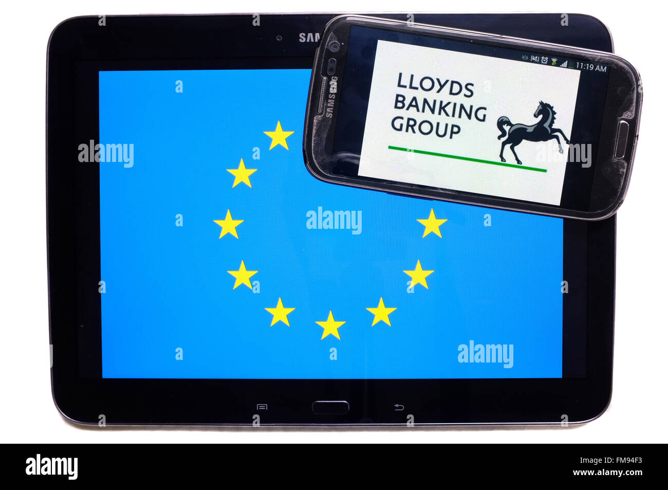 Un smartphone avec le logo de la Lloyds sur-le sur une tablette avec le drapeau de l'UE sur elle photographié sur un fond blanc. Banque D'Images