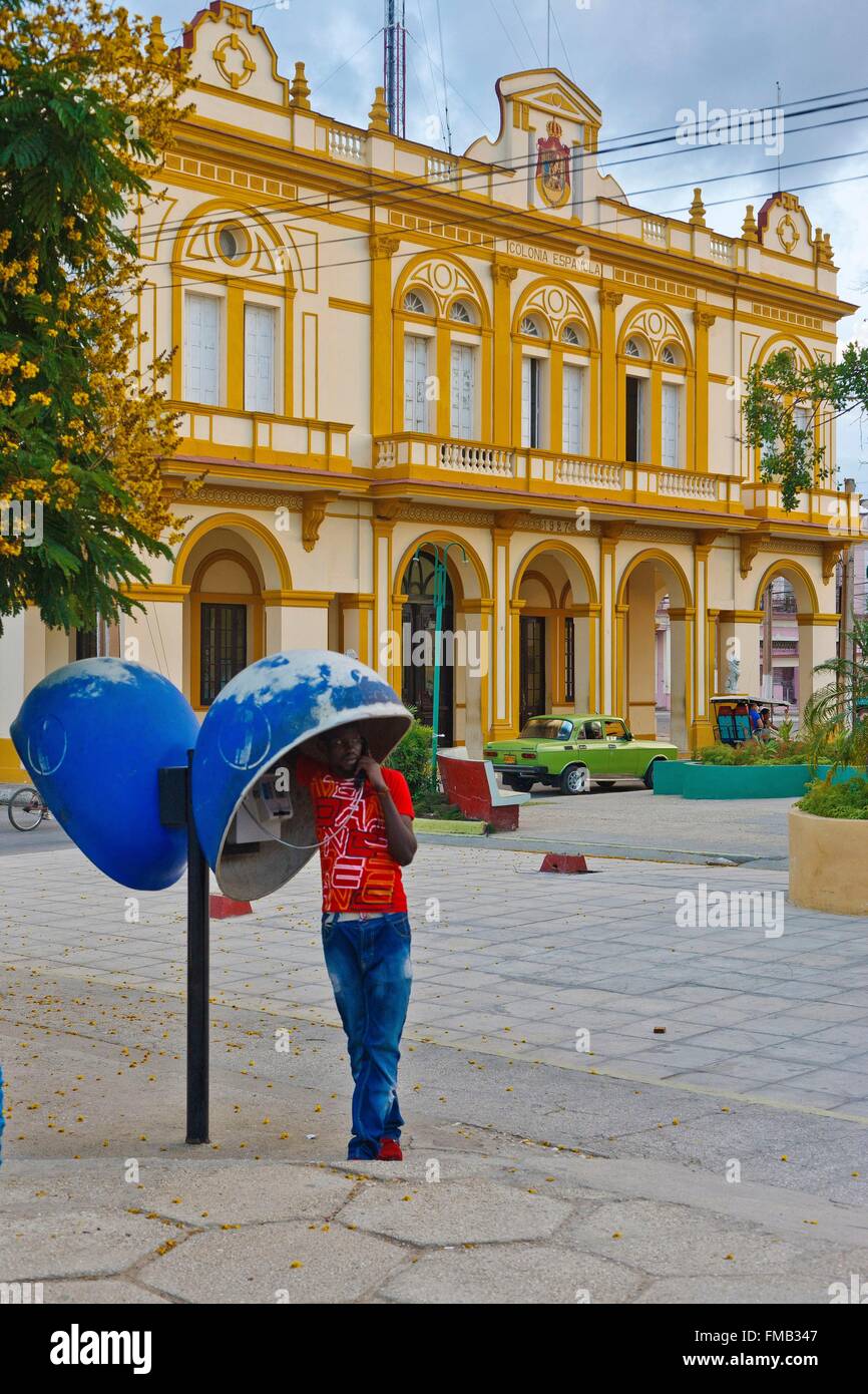 Cuba, Ciego de Avila, Moron, Man phoning dans un stand en face d'un bâtiment de style colonial Banque D'Images