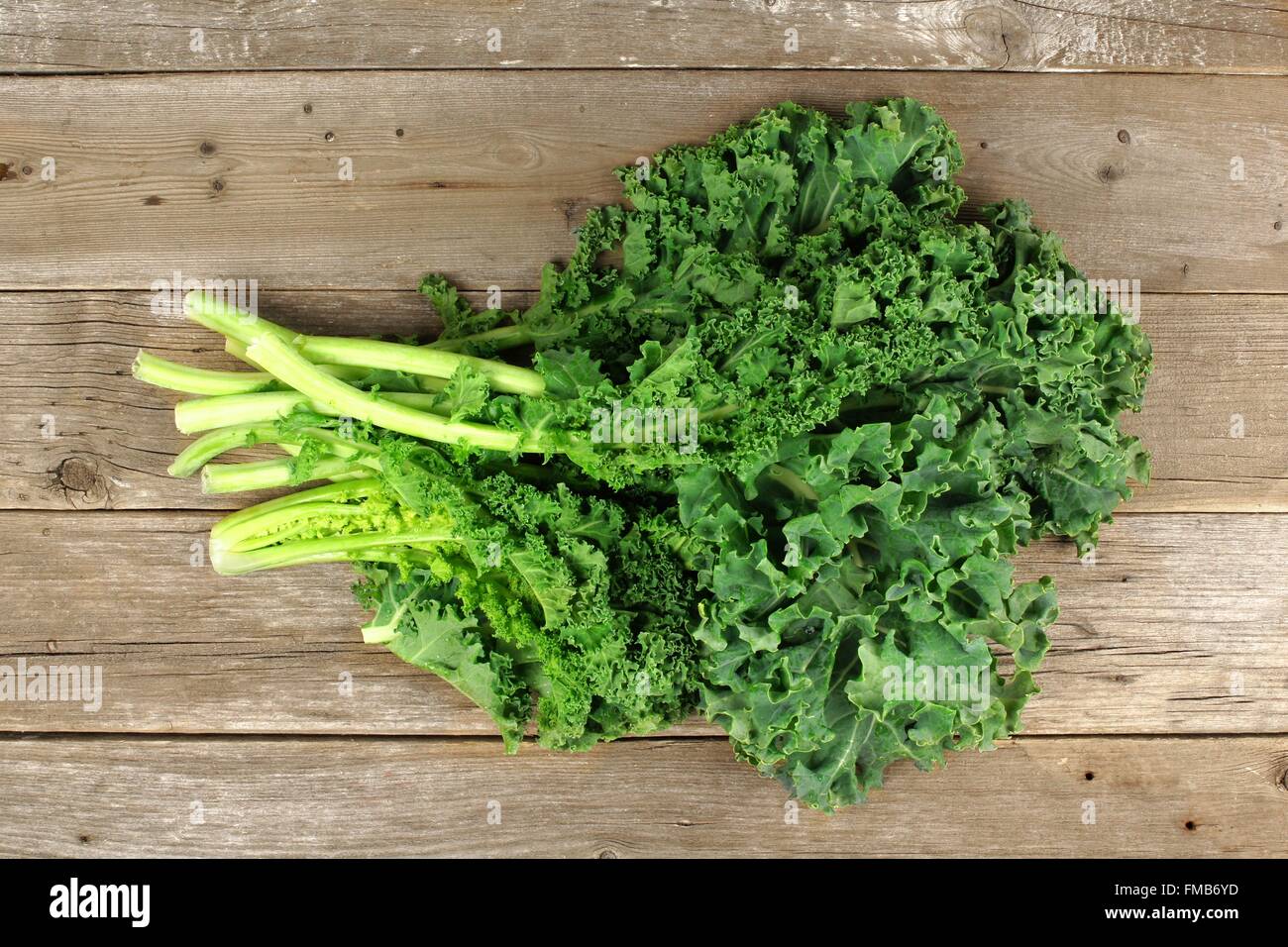 Bunch of fresh kale sur un fond de bois Banque D'Images