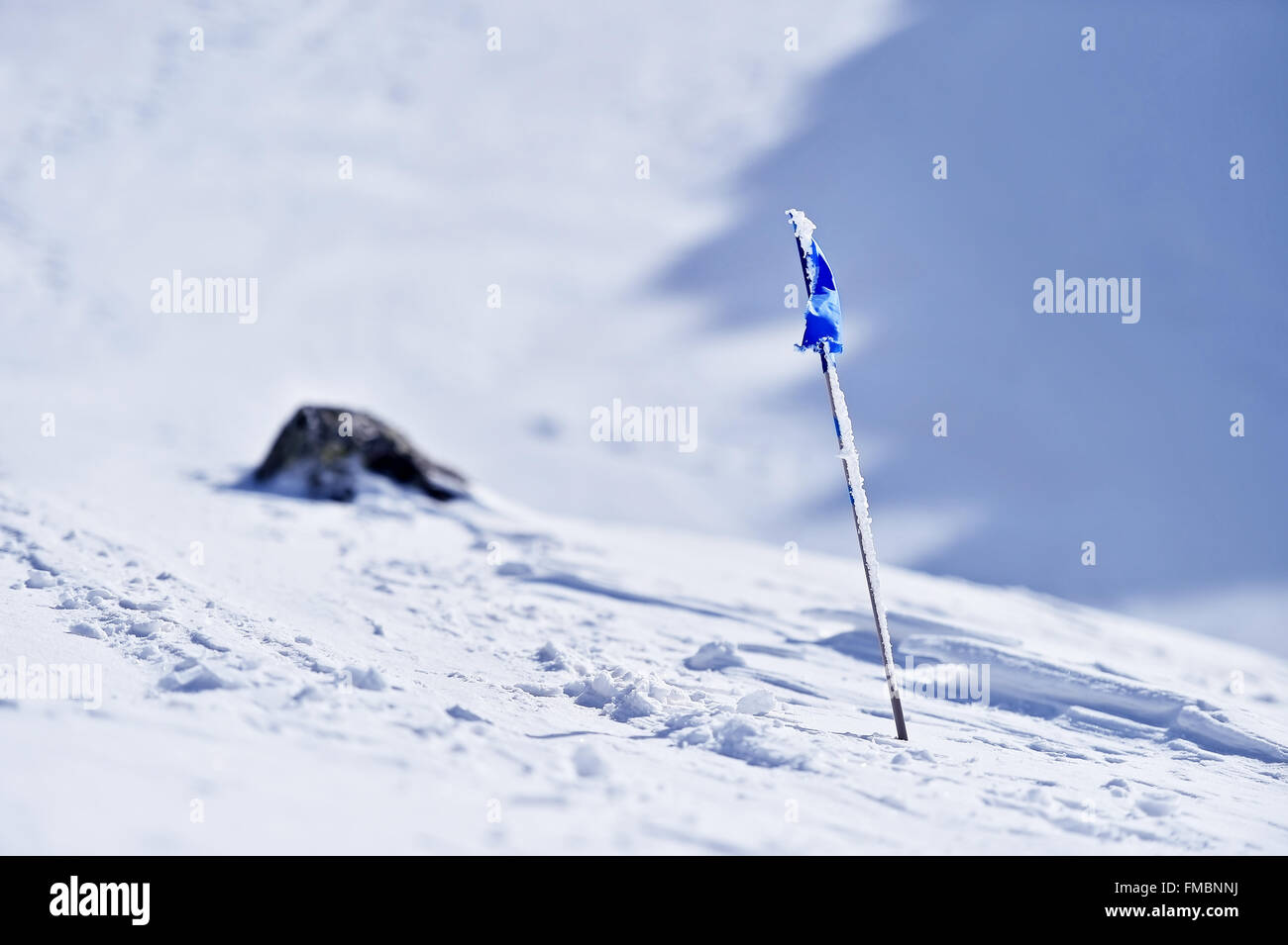 Drapeau bleu soufflé par le vent sur une montagne en hiver Banque D'Images