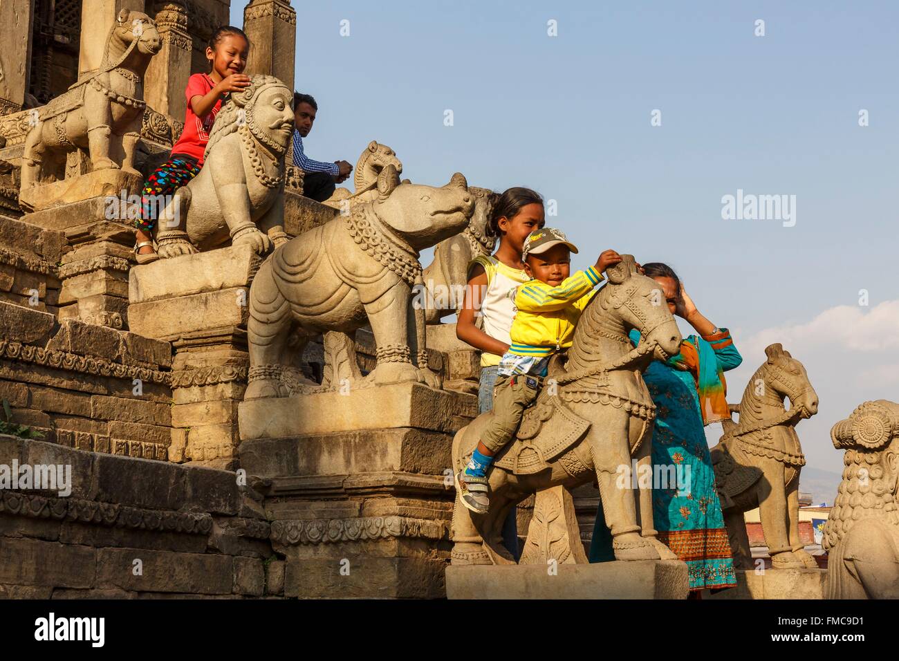 Le Népal, zone Bagmati, Bhaktapur, inscrite au Patrimoine Mondial de l'UNESCO, les enfants assis sur les statues du temple Siddhi Lakshmi Banque D'Images