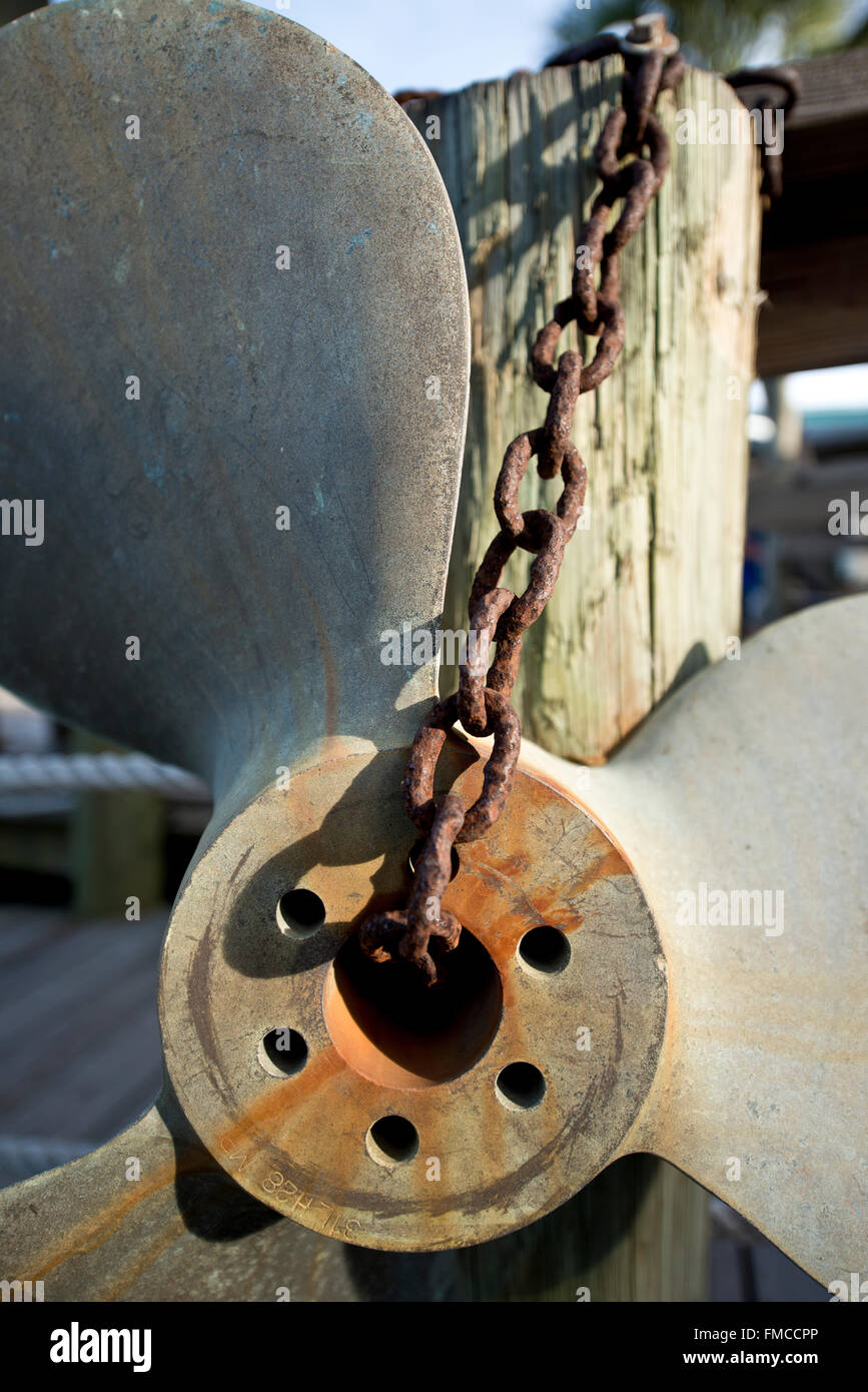 Old Rusty énorme hélice de bateau suspendu à une chaîne lourde sur un quai Banque D'Images