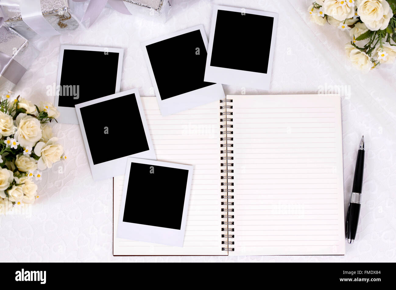 Album photo de mariage en blanc avec des impressions photo instantanée sur dentelle mariée avec plusieurs dons en argent et rose bouquets. Banque D'Images Album photo de mariage en blanc avec des impressions photo instantanée sur dentelle mariée avec plusieurs dons en argent et rose bouquets. Banque D'Images