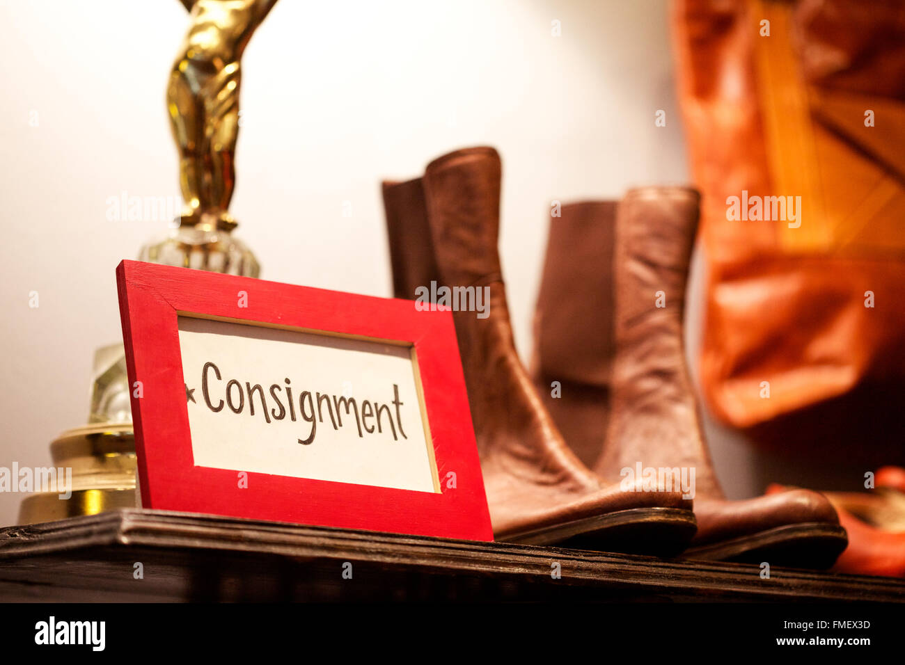 Un envoi sign assis sur une étagère dans un magasin de vêtements entourée d'articles à vendre. Banque D'Images