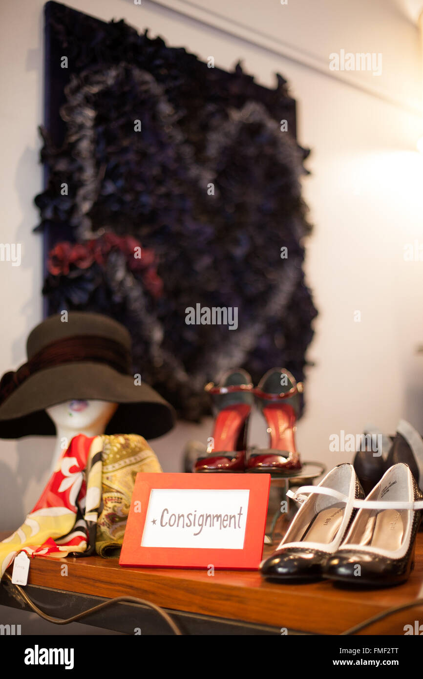 Un envoi sign assis sur une étagère dans un magasin de vêtements entourée d'articles à vendre. Banque D'Images