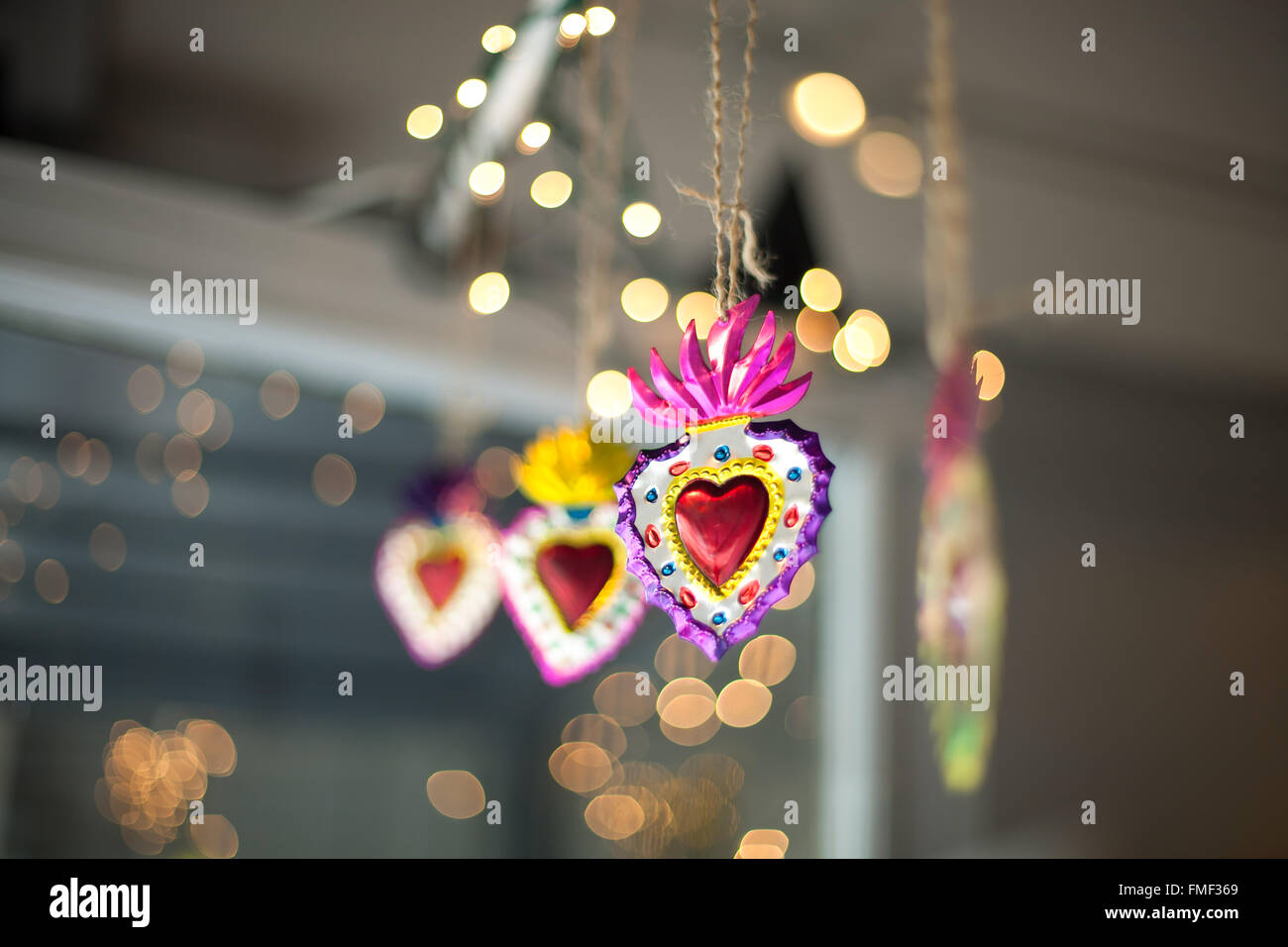 Décorations sacré-cœur accroché dans une fenêtre avec twinkle lights derrière eux. Banque D'Images