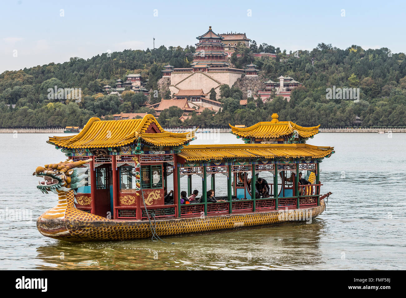 Les touristes sur un bateau dragon flottant sur le lac Kunming, Beijing, Chine. Palais d'été de l'arrière-plan. Banque D'Images