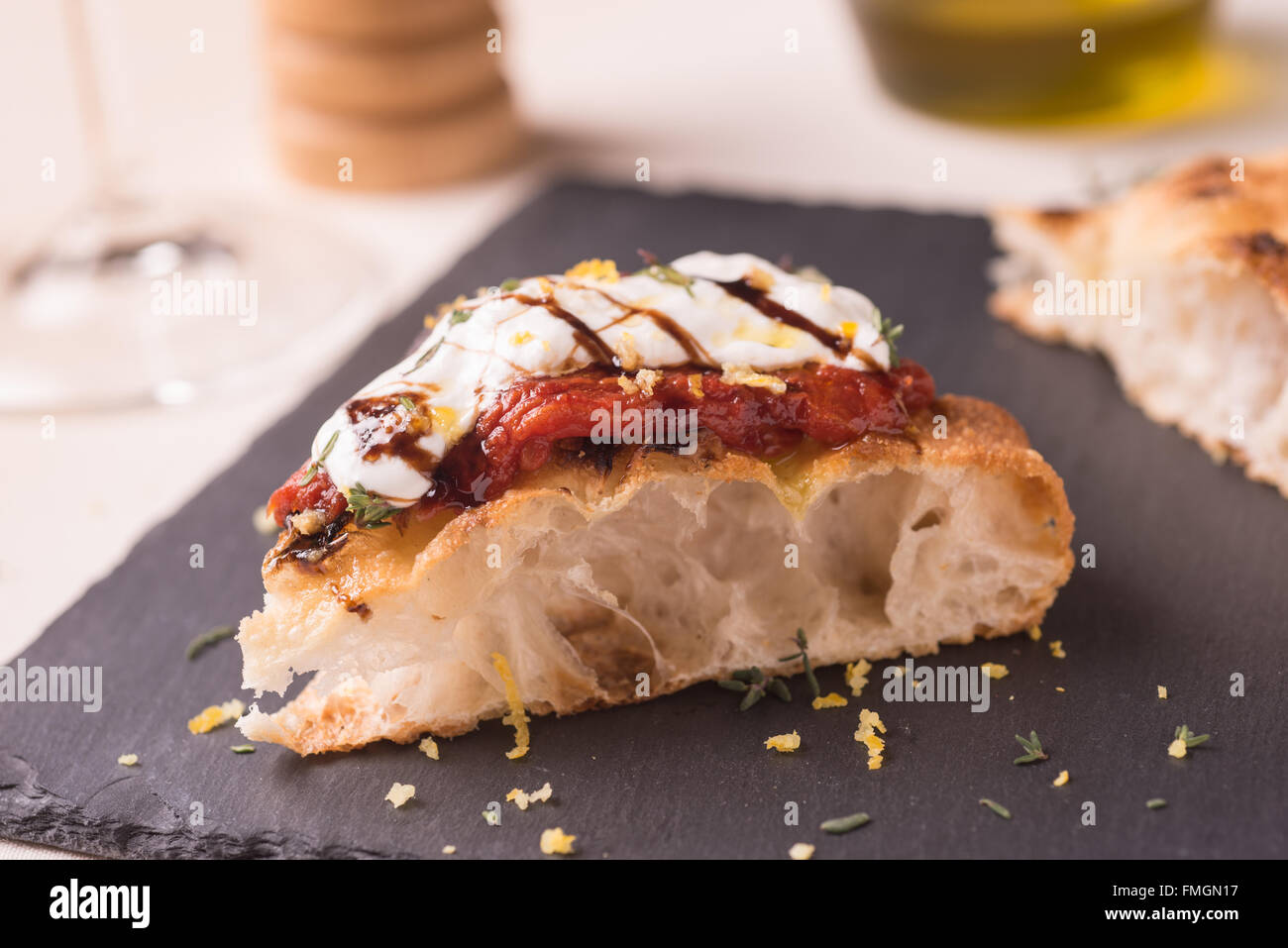 Tranche de pizza gourmt avec tomate adossés, italien burrata, winegar balsamique et zeste de citron Banque D'Images