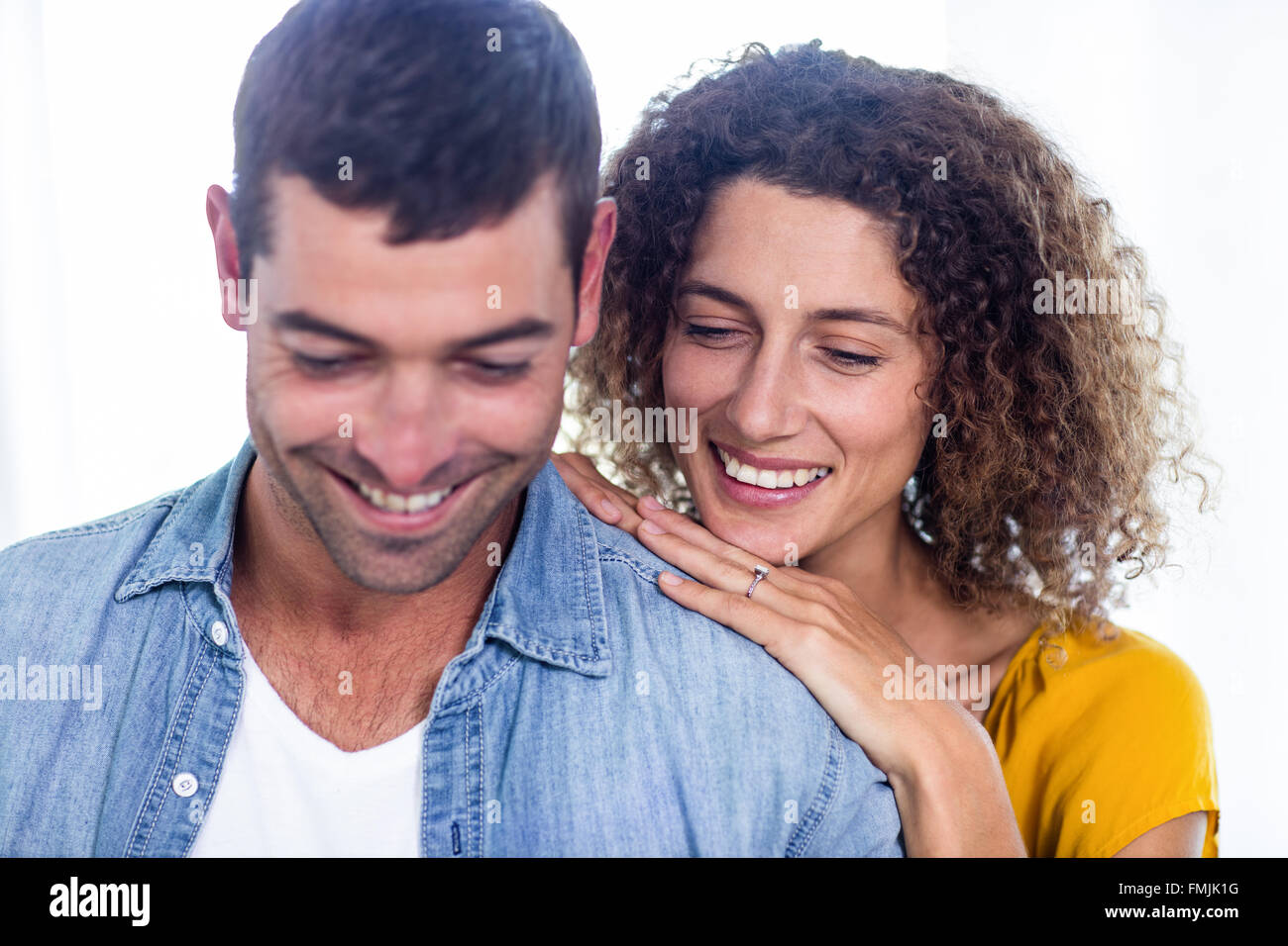 Happy couple looking down and smiling Banque D'Images