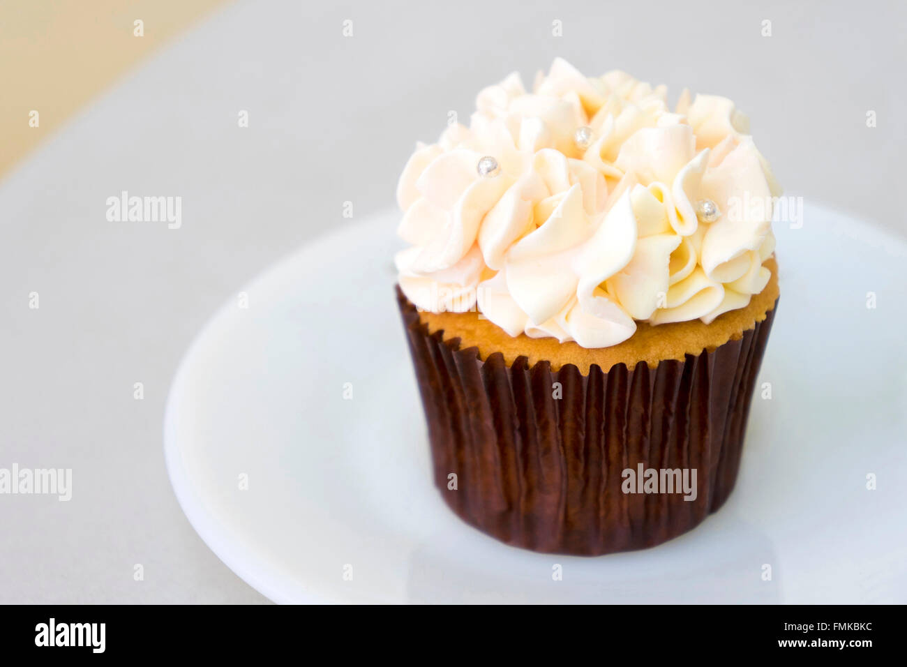 Cupcake à la vanille décoré avec des boules de couleur Banque D'Images