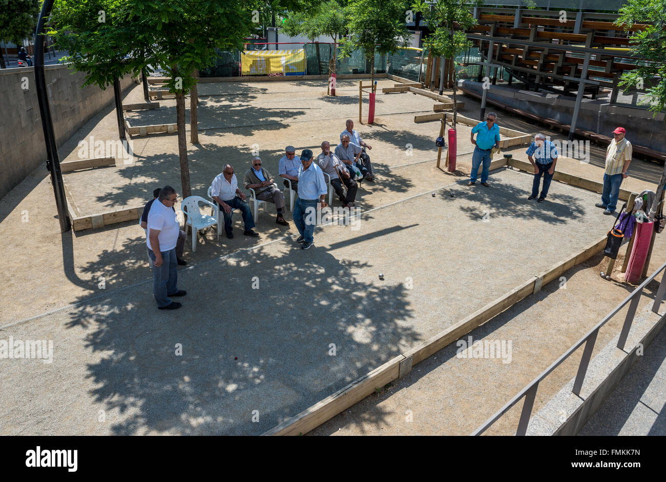 Hommes jouant aux boules dans petit parc à Barcelone, Espagne Banque D'Images