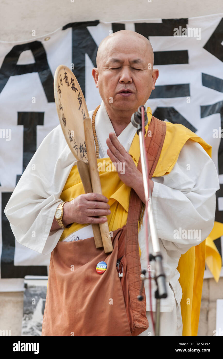 Londres, Royaume-Uni. 12 mars 2016. Le révérend Nagase, un moine bouddhiste au Battersea Park de la Pagode de la paix, dit une prière lors d'une manifestation tenue devant les Maisons du Parlement à Westminster pour reconnaître le cinquième anniversaire de la catastrophe nucléaire de Fukushima au Japon et pour protester contre les plans du gouvernement japonais pour redémarrer l'usine nucléaire de Sendai. Crédit : Stephen Chung/Alamy Live News Banque D'Images