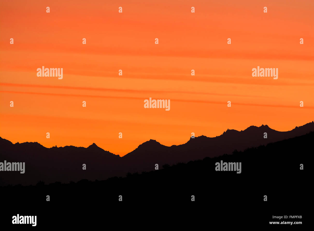 Un coucher de soleil spectaculaire dans les collines de Palm Springs montre belles stries dans un profond ciel orange Banque D'Images