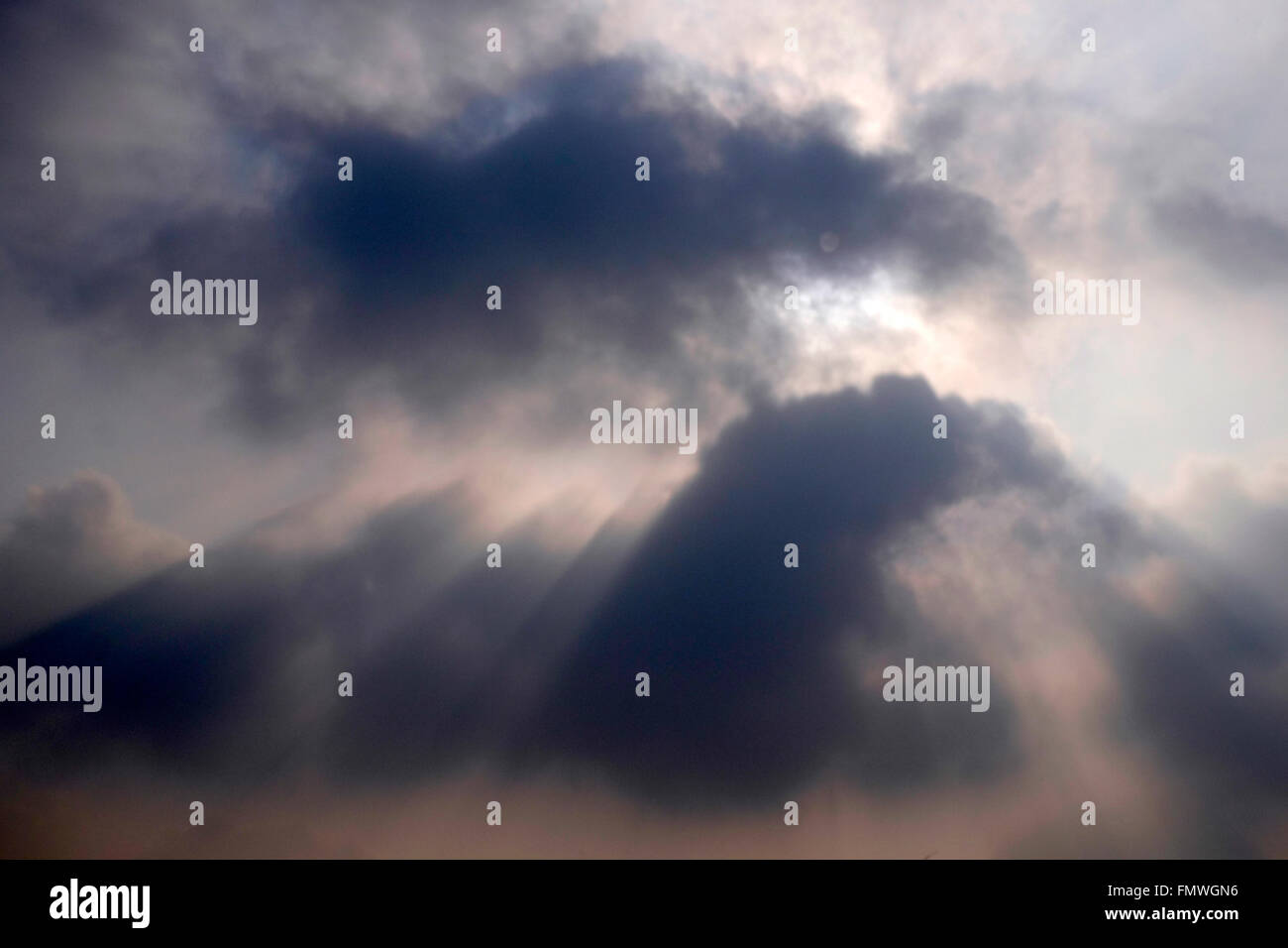 Soleil qui brille à travers les nuages lourds Banque D'Images