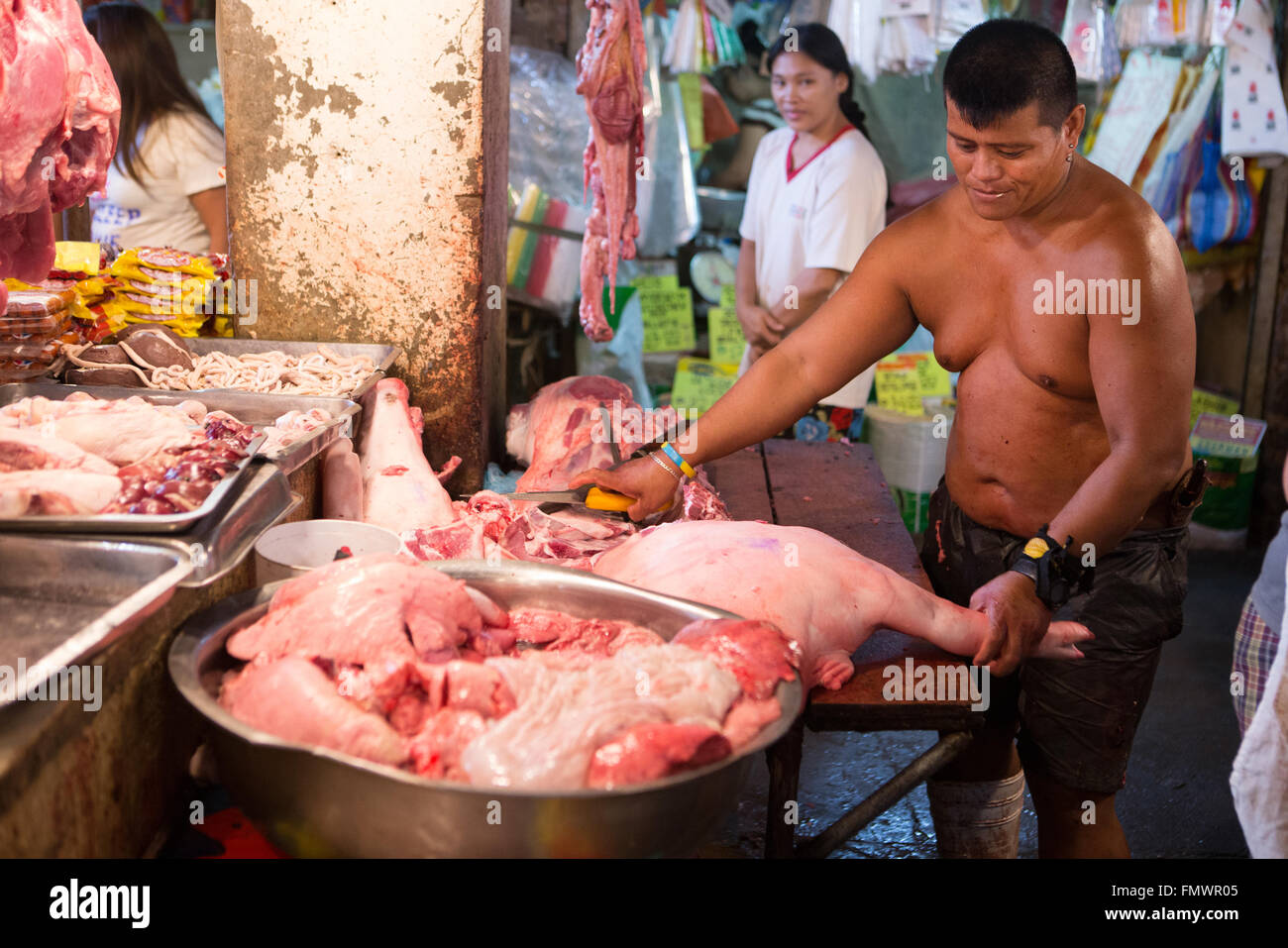 Un homme de son pays les bouchers un cochon dans le marché traditionnel de Talisay,la ville de Cebu. Banque D'Images